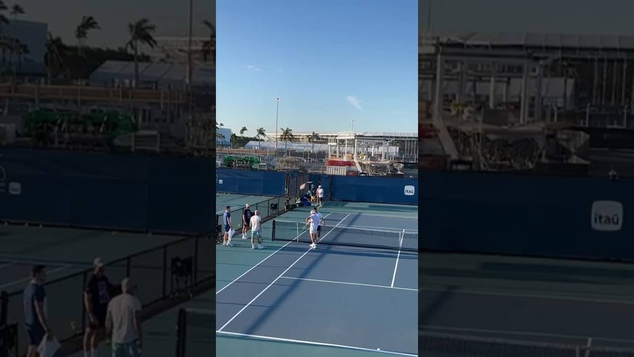 Holger Rune spins his racket on the ground while chatting with Carlos Alcaraz during Miami practice